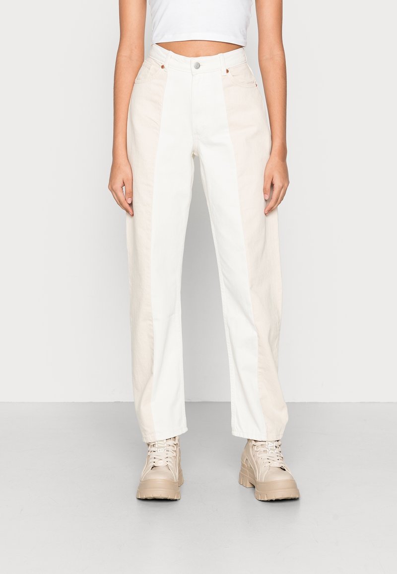 Höga byxor i en ljus beige och vit colorblock-design, med rak passform, knappstängning och sidofickor.