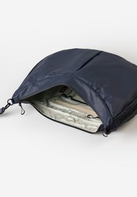 Borsa a spalla imbottita blu navy con zip aperta che rivela una tasca interna chiara e scomparti per l'organizzazione.