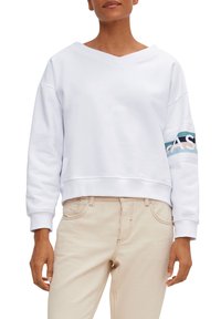 Witte cropped sweatshirt met een v-hals, met een veelkleurige band over de linker mouw met het woord "EASY." Zachte textuur, relaxte pasvorm.