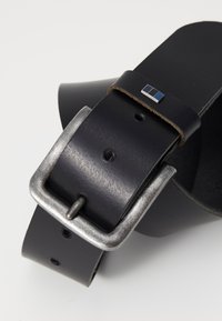 Black leather belt with a silver metal buckle, featuring a small blue and silver rectangular accent near the buckle. Textured surface, multiple holes.