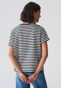 Gestreept t-shirt in zwart en wit, gemaakt van zachte katoen, heeft een relaxed fit met een ronde hals en korte mouwen.