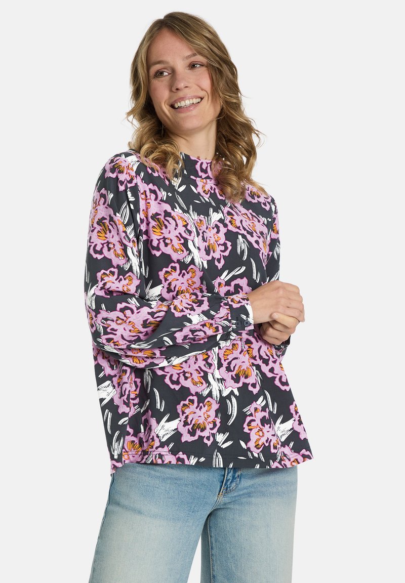 Floral long-sleeve top featuring a dark background with pink, purple, and orange flowers. Soft fabric, relaxed fit, and high neckline.