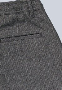 Graue, strukturierte Hose mit feinem Streifenmuster, Seitentasche und Bund mit Gürtelschlaufen. Das Material scheint gewebt und strukturiert zu sein.