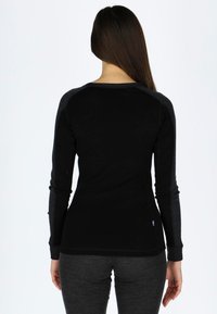Zwarte longsleeve shirt met grijze raglanmouwen, met een slim fit ontwerp en een klein logo op de onderrug. Zachte textuur.