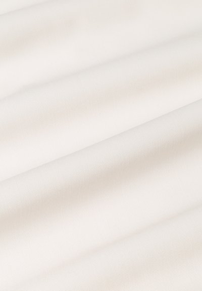 Tissu blanc avec une surface lisse et texturée, légèrement froissé, présentant une couleur uniforme sans motifs ni matériel visible.