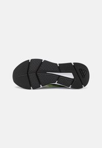 Semelle de chaussure en caoutchouc noir avec grip texturé, design angulaire et accents blancs. Présente des crans espacés et un logo de marque bien visible.