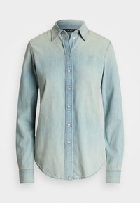 Šviesiai mėlynos džinsinio audinio marškiniai su smailiu apykakle, mygtukų užsegimu priekyje ir ilgomis rankovėmis su apvaliu pakraščiu. Subtili gradientinė tekstūra.
