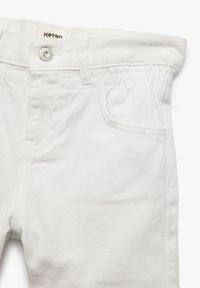 Pantalones de denim blanco con un diseño clásico, cierre de botón, cintura elástica y bolsillos frontales. Textura suave sin patrones.