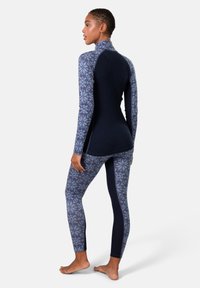 Marineblauw en gemêleerd thermisch activewearset, met een top met hoge kraag en gemêleerde mouwen en bijpassende leggings, gemaakt van textuurstof.