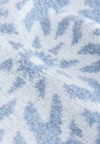 Tessuto intrecciato con motivi geometrici blu e bianchi, caratterizzato da una superficie morbida e strutturata adatta per abbigliamento o tessuti per la casa.