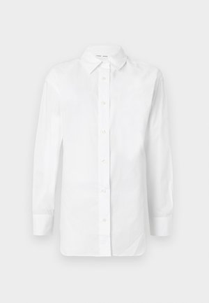 Chemise blanche à manches longues avec boutons, col pointu et coupe ajustée, présentée sur un fond neutre.