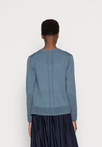 Blaues Langarmhemd aus weicher Baumwolle mit geripptem Saum, einer strukturierten Rückennaht und abgerundetem Ausschnitt.