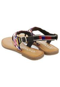 Sandalias de tela con cuentas y tiras negras, hebilla ajustable y suela color tostado. Presentan patrones de cuentas coloridos y un diseño plano.