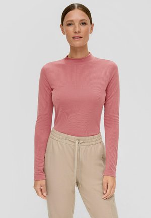 Haut à manches longues en tissu à rayures rose doux avec un col montant, associé à un pantalon beige à cordon de serrage. Texture lisse, design ajusté.