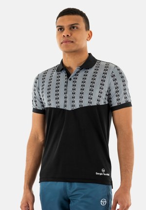 Polo shirt à manches courtes noir et gris avec un haut à motif, présentant des rayures et des accents de logo. Partie inférieure noire unie. Tissu texturé.