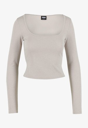 Világosszürke, hosszú ujjú felső négyzet alakú dekoltázzsal, texturált anyagból, amely enyhe fényt ad. Testhez simuló fazon, rövidített szegéllyel.