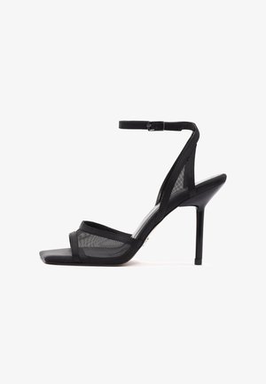 Sandalias de tacón alto negras que cuentan con materiales de malla y satén, diseño de punta abierta, tiras estrechas, hebilla en el tobillo y un tacón de aguja.