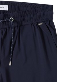 Pantalones con cinturilla elástica en azul marino, confeccionados con una tela suave, que cuentan con un cordón ajustable con puntas de plata y una etiqueta metálica etiquetada como "CECIL".