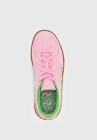 Pink suede sneaker with green accents, featuring a lace-up design and patterned insole, set against a white background.
