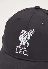 Schwarze Baseballmütze mit gebogenem Schirm; auf der Vorderseite mit dem weißen gestickten Logo des Liverpool Football Clubs und der Aufschrift "L.F.C.".