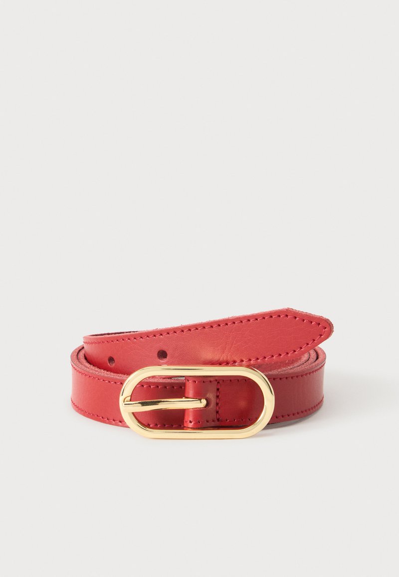 Ceinture en cuir rouge roulée avec une boucle ovale dorée brillante et des coutures visibles sur les bords.