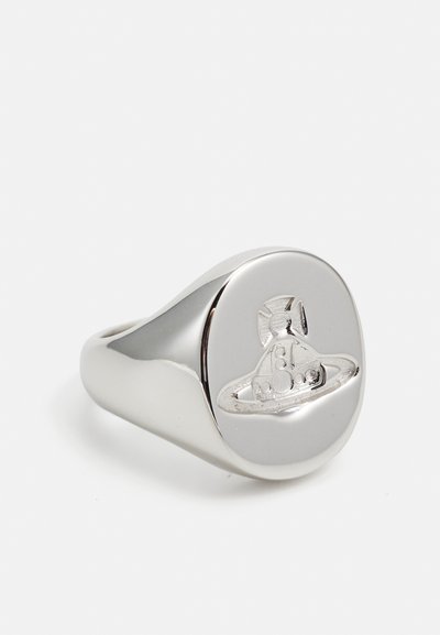 Anillo de sello de plata con una parte superior suave y redondeada, adornada con un diseño grabado de una nave espacial. Metal pulido con un acabado brillante.