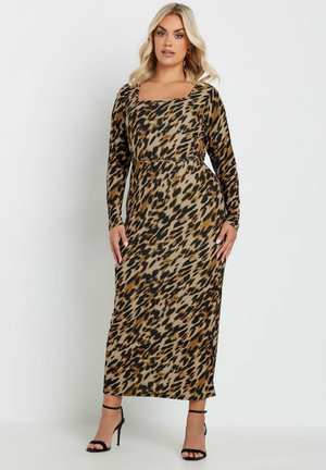 Abito maxi con stampa leopardata in tessuto elasticizzato, dotato di maniche lunghe, scollatura quadrata e vita accentuata. Tacchi neri con cinturini.