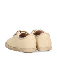 Zapatillas de lona beige con forma redonda y un upper texturizado, que cuentan con una suela envuelta en yute y un cierre de cordones sencillo.