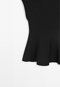 Černá žebrovaná pletenina s prohnutým švem, který na oděvu vytváří zvonový peplum v pase.