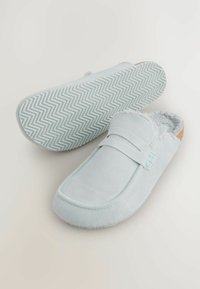 Világoskék velúr, slip-on papucsok puha béléssel, texturált talppal és steppelt mintázattal. Elöl emelt pánttal rendelkezik.