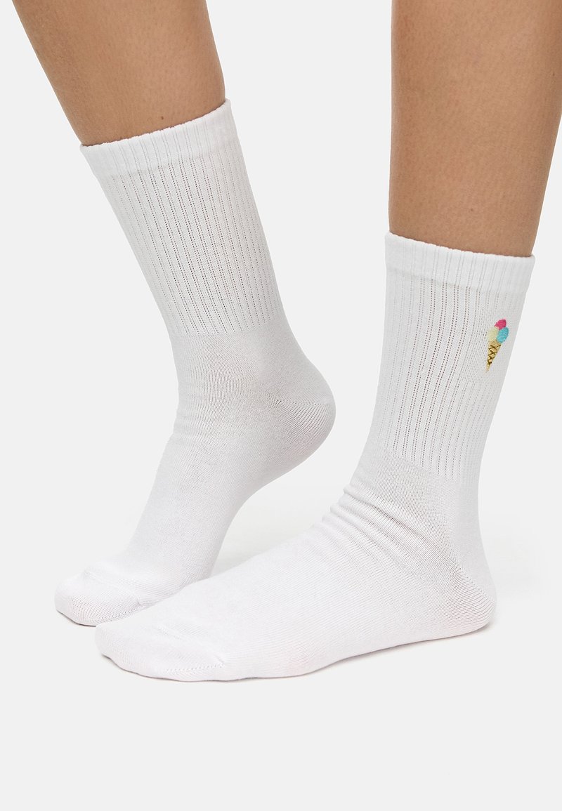Calcetines de algodón blancos de corte medio que presentan una textura acanalada y un pequeño cono de helado multicolor bordado en el lado exterior.