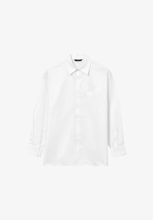 Camicia bianca con maniche lunghe e colletto a punta, bottoni frontali nascosti, polsini abbottonati e tasca triangolare sul lato sinistro del petto.