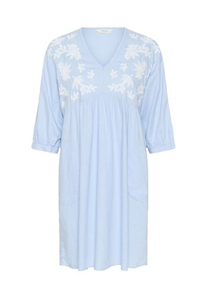 Világoskék pamutruha V-nyakkivágással, ¾-es ujjakkal, és fehér virágos hímzéssel a mellrészen. Két oldalsó zsebe van.