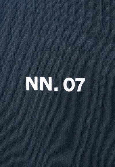 Tumši zils adīts audums ar izvērstu baltu tekstu "NN. 07" centrā uz virsmas.