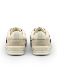 Sneaker beige con tomaia in camoscio e pelle, punta arrotondata, colletto imbottito, suola testurizzata e accenti scuri in contrasto sui lati.