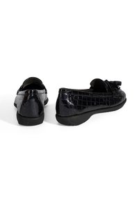 Schwarze Lacklederschuhe im Loafer-Stil mit Krokodilstruktur, flachen Gummisohlen und einer dekorativen Schleifenakzent auf der Vorderseite.