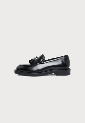 Mocassin noir en cuir orné d’un pompon, à bout arrondi et à talon bas et épais, vu de profil.