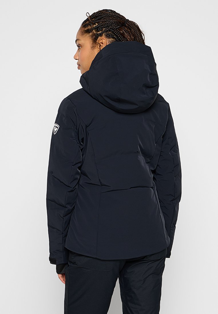 Marine pufferjack op met capuchon, met een gladde textuur, een gewatteerd ontwerp en een logo patch op de bovenarm. Biedt een aansluitende pasvorm.