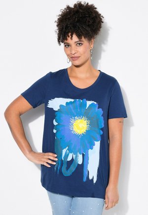 Camiseta azul marino con cuello redondo y mangas cortas, que presenta un gran diseño gráfico floral en azul y amarillo. Textura de tela suave.