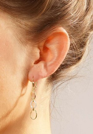 Goldfarbene Creolen mit verbundenen ovalen Formen und einer einzelnen runden Verzierung, die mit kleinen klaren Steinen besetzt ist.