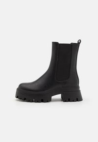 Black ankle boots with a chunky sole, composed of leather and elastic side panels. Features a pull tab at the heel for easy wearing.