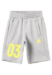 Harmaat urheilushortsit, jotka on valmistettu pehmeästä kankaasta, joissa on sivutaskut, joustava vyötärö ja suuri keltainen "03" -painatus Adidas-logolla.