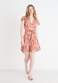 Kurzärmeliges Wickelkleid aus orangefarbenem Stoff mit weißen und blauen Blattmustern, ausgestelltem Rock und gebundenem Taillengürtel.