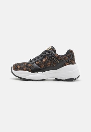 Sneaker nera con tomaia decorata, dettagli arancioni, suola intermedia bianca e suola esterna nera. Logo "GUESS" visibile sul lato.
