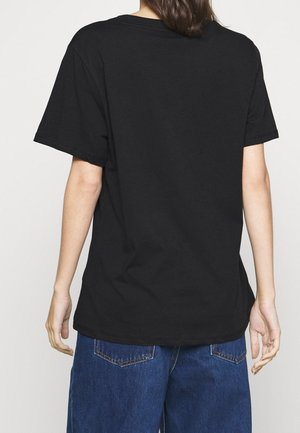 T-shirt in cotone nero con maniche corte, vestibilità rilassata e scollo rotondo, vista da dietro. Presenta una superficie liscia senza motivi.