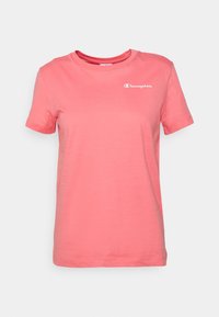 T-shirt in cotone rosa con colletto rotondo, maniche corte e un piccolo logo bianco sul petto. Texture morbida e taglio casual.