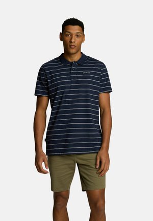 Granatowa polo w paski z kołnierzykiem i guziczkami, w połączeniu z oliwkowymi szortami. Krótkie rękawy, bawełniany materiał, casualowy krój.