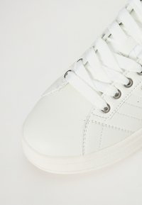 Weißer Ledersneaker mit runder Zehenform, flachen weißen Schnürsenkeln und silberfarbenen Ösen. Verfügt über subtile Nähte und eine glatte Textur.