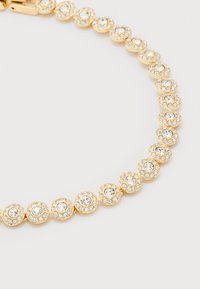 Χρυσό βραχιόλι με στρογγυλούς συνδέσμους επικαλυμμένους με κρύσταλλα, που σχηματίζουν μια συνεχή, λαμπερή αλυσίδα σε λευκό φόντο.