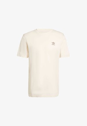 T-shirt in cotone color crema con maniche corte e scollatura a girocollo, caratterizzato da un piccolo logo Adidas marrone sul lato sinistro del petto.